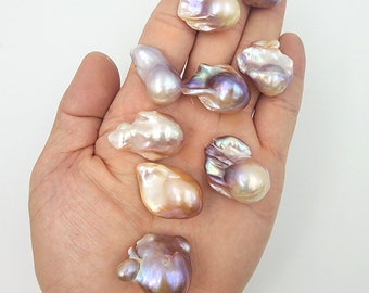 May include: A selection of iridescent baroque pearls in a hand. The pearls vary in shape and size, displaying colours such as white, pink, and purple, with a shiny surface. The image includes the text "GOTBEAD BEAD FOR YOU".