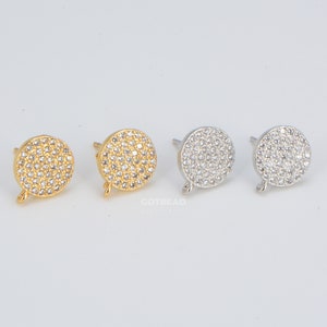 May include: Four earring findings with a round, pave-set design. Two are gold-toned and two are silver-toned.