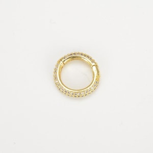 May include: A gold-toned hoop earring with a single row of clear cubic zirconia stones.
