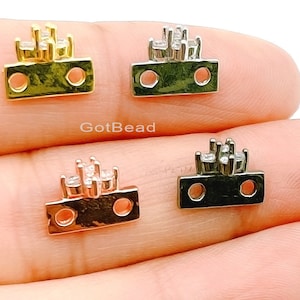 May include: Three metal connector charms with a crown design and clear rhinestones. The charms are in gold, silver, and black.