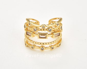 May include: Gold ring with multiple bands, each adorned with clear cubic zirconia stones. The bands are twisted and feature a rope-like design. PaveFindings4U is printed on the white background.