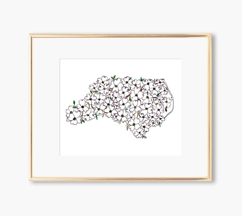May include: A framed print of a white dogwood flower design in the shape of the state of North Carolina.