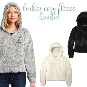 Pode incluir: Tr&ecirc;s hoodies de fleece aconchegantes em cinza, branco e preto. O hoodie cinza tem o texto "TEXT OR NAME" bordado na frente.