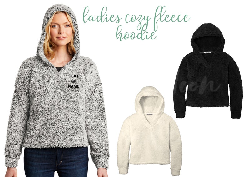 Pode incluir: Tr&ecirc;s hoodies de fleece aconchegantes em cinza, branco e preto. O hoodie cinza tem o texto "TEXT OR NAME" bordado na frente.