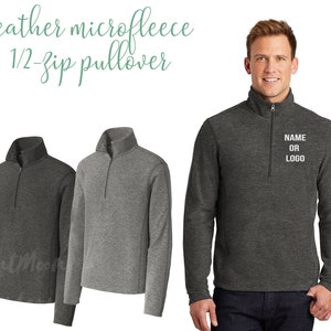 May include: Heather microfleece 1/2-zip pullover in dark gray and gray. The image shows three pullovers, with one being modeled. The pullover has a mock neck collar and a zipper that goes halfway down the chest. The text "NAME OR LOGO" is on the chest.