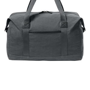 May include: A charcoal gray canvas duffel bag featuring a rectangular main compartment with a top zipper closure, two sturdy fabric handles with black leather-like grips, and a horizontal front pocket accented with a black trim detail.