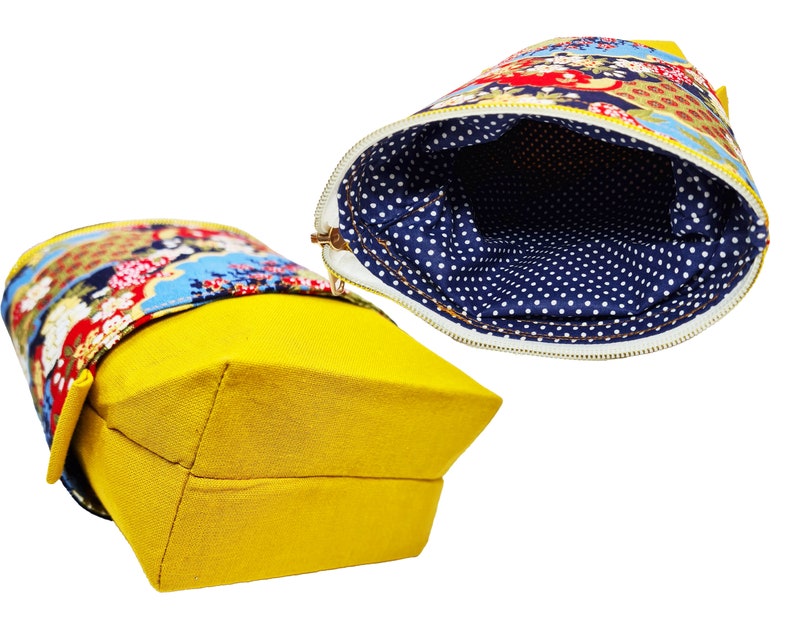 May include: A yellow canvas zippered pouch with a floral patterned fabric lining. The pouch is open to show the blue and white polka dot lining.
