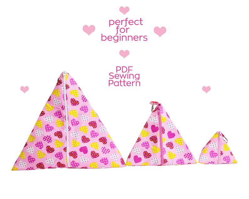 Pode incluir: Tr&ecirc;s bolsas triangulares com z&iacute;per rosa com um padr&atilde;o de cora&ccedil;&atilde;o. As bolsas s&atilde;o de tamanhos diferentes e est&atilde;o dispostas da maior para a menor. O texto "PDF Sewing Pattern" est&aacute; escrito em preto sobre fundo branco.