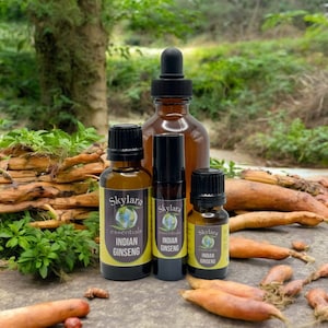 Peut inclure: Quatre flacons en verre brun avec des compte-gouttes contenant de l'huile essentielle de ginseng indien. Les flacons sont &eacute;tiquet&eacute;s "Skylara Essentials Indian Ginseng". Les flacons sont pos&eacute;s sur une surface en bois avec des racines orange.