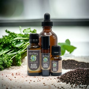 May include: Four brown glass bottles of black pepper essential oil with a white label that says "Skylara Essentials Black Pepper".