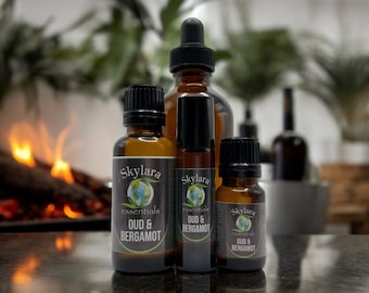 May include: Three brown glass bottles with black labels and gold lettering. The labels read "Skylara essentials OUD & BERGAMOT".