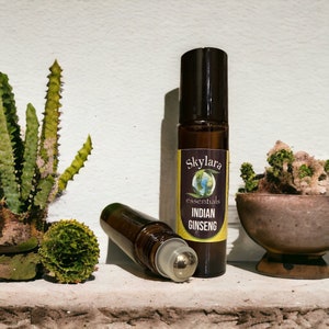 Peut inclure: Un flacon en verre brun avec un applicateur &agrave; bille en m&eacute;tal. Le flacon porte une &eacute;tiquette jaune avec le texte "Skylara essentials INDIAN GINSENG".