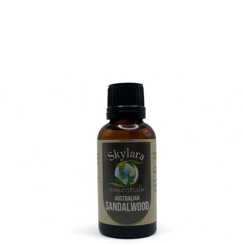 Puede incluir: Una botella de vidrio marr&oacute;n de aceite esencial de s&aacute;ndalo australiano Skylar essentials. La etiqueta presenta el nombre de la marca, un gr&aacute;fico de globo y el nombre del producto en un esquema de color marr&oacute;n oscuro y verde. La botella tiene una tapa negra.