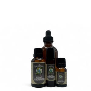 Puede incluir: Cuatro botellas de vidrio &aacute;mbar de aceites esenciales. Las botellas tienen tapas negras y etiquetas que dicen "Skylara essentials AUSTRALIAN SANDALWOOD". Una botella tiene un cuentagotas. Las botellas son de diferentes tama&ntilde;os.