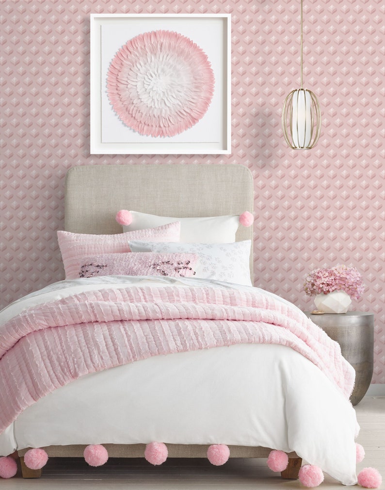 K&ouml;nnte beinhalten: Ein wei&szlig;es Bett mit einem rosa, gekr&auml;uselten Bett&uuml;berwurf und einem rosa-wei&szlig; gemusterten Kopfteil. Das Bett hat ein wei&szlig;es Kissen mit einem rosa Blumendesign und ein rosa Kissen mit einem wei&szlig;en Blumendesign. Das Bett steht in einem Zimmer mit rosa Tapete und einem wei&szlig;en gerahmten Bild einer rosa Blume.