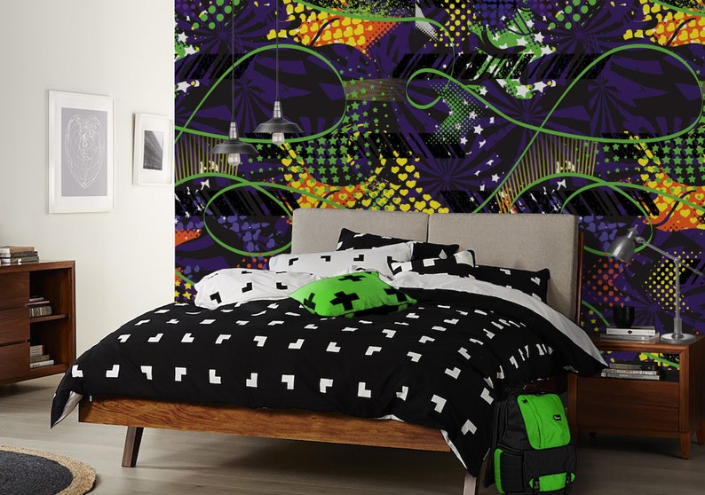 May include: A bedroom with a black and white patterned bedspread and a green and yellow patterned wallpaper. The wallpaper features abstract shapes and designs. There is a green backpack on the floor next to the bed.