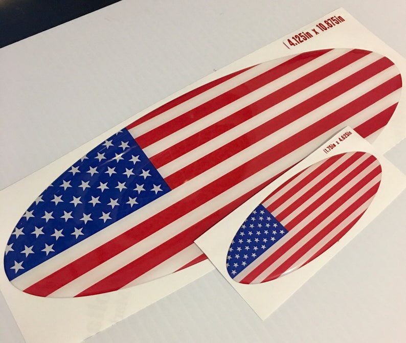 May include: Two oval-shaped American flag stickers. The larger sticker measures 4.125 inches by 10.875 inches. The smaller sticker measures 1.75 inches by 4.625 inches.
