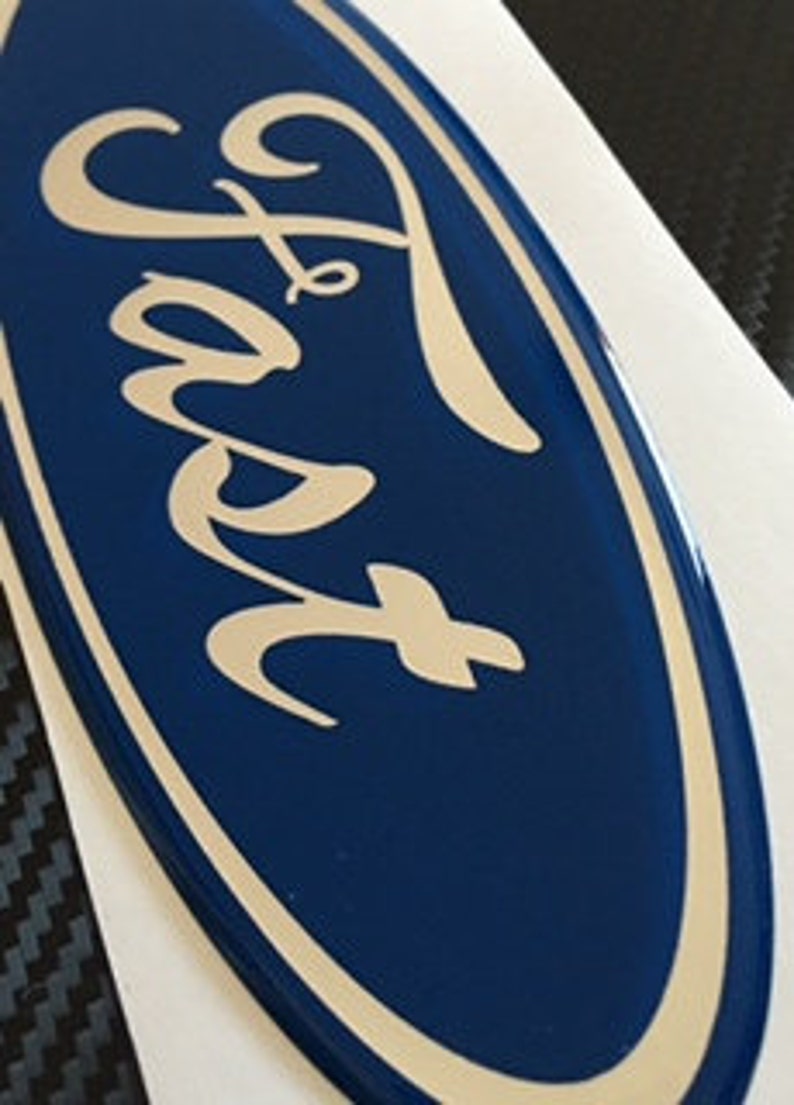 May include: A blue oval-shaped emblem with the word "Ford" in a silver script font.