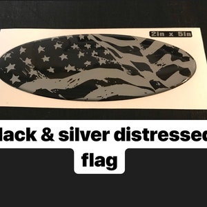 May include: A black and silver distressed American flag decal, 2 inches by 5 inches.