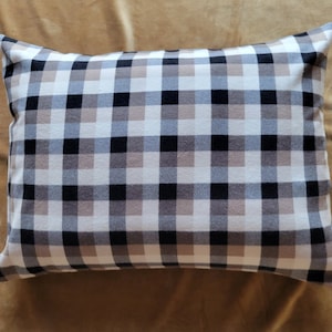 May include: A black and white checkered pillow with a beige background. The pillow is made of a soft, comfortable fabric and is perfect for adding a touch of style to any room.