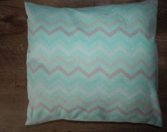 May include: A light green and white pillow with a chevron pattern. The pillow has a subtle pink dotted pattern throughout.