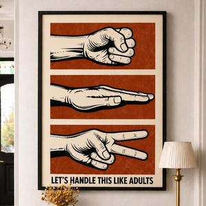 May include: A framed rectangular wall art print featuring three horizontal panels with illustrations of hands forming rock, paper, and scissors gestures against a rust-coloured background. The text "LET'S HANDLE THIS LIKE ADULTS" is printed in black at the bottom.
