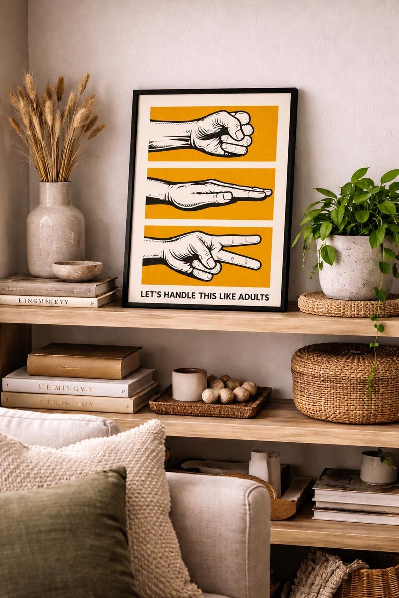 May include: A framed rectangular wall art print featuring three horizontal yellow panels, each displaying a black and white illustration of a hand gesture representing rock, paper, and scissors. The text LET'S HANDLE THIS LIKE ADULTS is printed in black at the bottom.