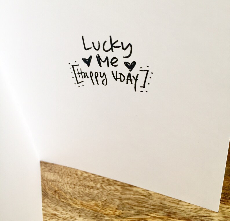 May include: A white card with black ink that says "Lucky Me Happy Vday!" with two hearts.