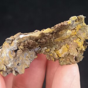 Pu&ograve; includere: Un pezzo di minerale di rame ruvido e irregolare di colore marrone, grigio e giallo. Il minerale ha una superficie stratificata e testurizzata.