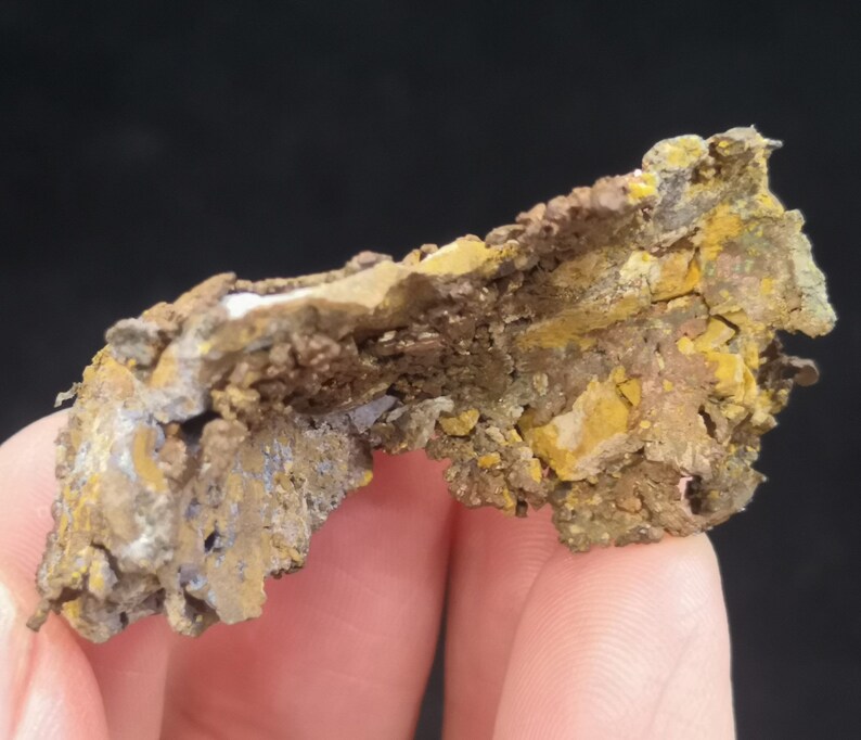 Pu&ograve; includere: Un pezzo di minerale di rame ruvido e irregolare di colore marrone, grigio e giallo. Il minerale ha una superficie stratificata e testurizzata.