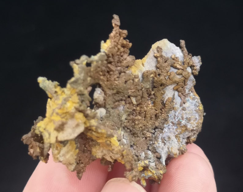 Pu&ograve; includere: Un gruppo di cristalli di rame con un'abitudine di crescita dendritica e ramificata. I cristalli sono una miscela di colori giallo dorato e marrone rossiccio.