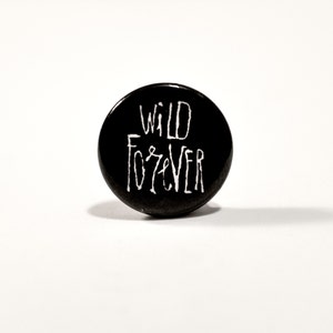 Pode incluir: Botão preto com texto branco que diz "WILD FOREVER".