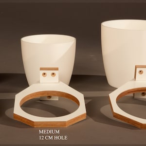 May include: Three white ceramic plant pots with wooden wall mounts. The pots are labeled "Small 6.5cm Hole", "Medium 12cm Hole", and "Large 15.5cm Hole".