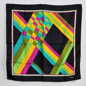 May include: A black silk scarf with a geometric pattern of yellow, green, pink, and blue stripes. The scarf has a white border and the word "Echo" is printed in the bottom right corner.