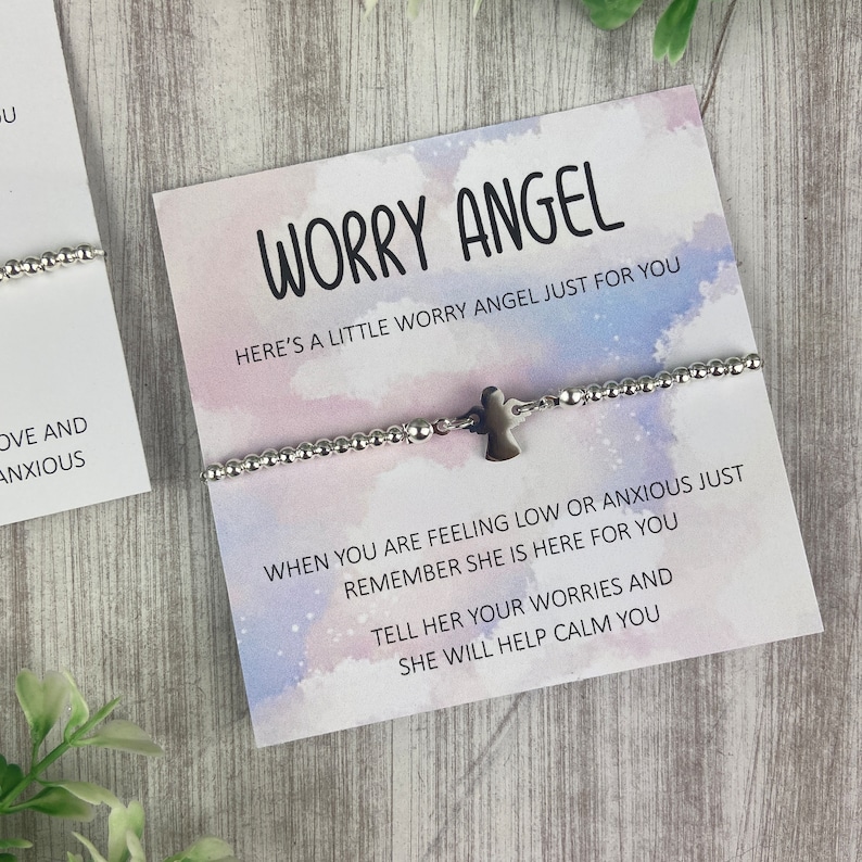 May include: A silver bracelet with a small angel charm on a white card with the text "Worry Angel" and "Here's a little worry angel just for you" on a watercolour background. The card also includes the text "When you are feeling low or anxious just remember she is here for you. Tell her your worries and she will help calm you."