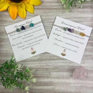 May include: Two cards with text describing the benefits of crystals for menopause and perimenopause relief. Each card features a silver bracelet with different colored crystals.