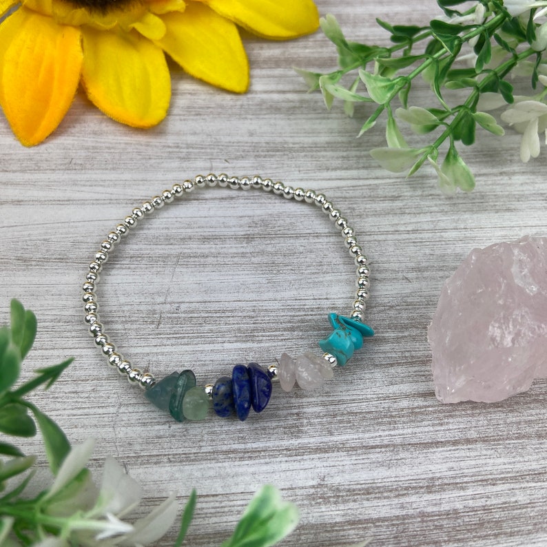 May include: A silver beaded bracelet with a variety of semi-precious stones, including turquoise, lapis lazuli, and rose quartz.