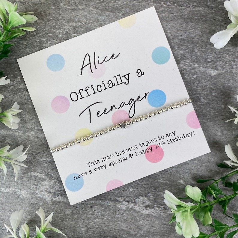 May include: A white card with colorful polka dots and the text "Alice Officially a Teenager" with a silver beaded bracelet with a star charm. The card says "This little bracelet is just to say have a very special & happy 18th birthday!"