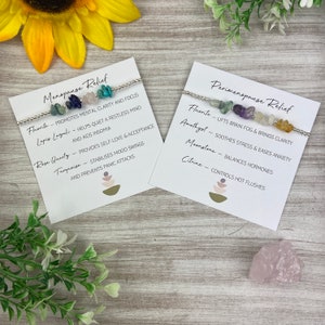 May include: Two bracelets with different colored gemstones and silver beads. The bracelets are labeled "Menopause Relief" and "Perimenopause Relief" with a list of the gemstones and their benefits.