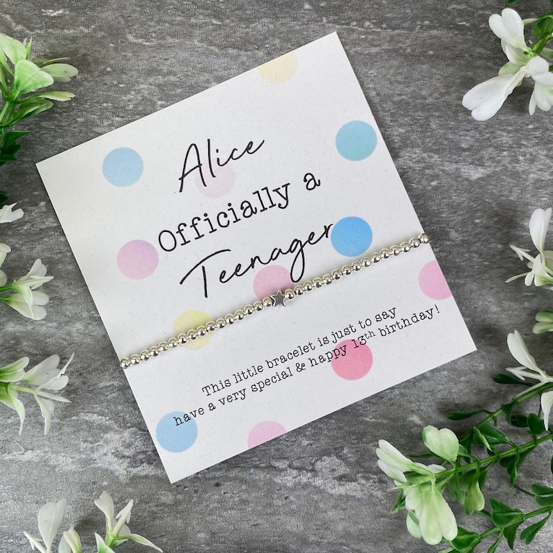 May include: A white card with colorful polka dots and the text "Alice Officially a Teenager" with a silver bracelet with a star charm. The card says "This little bracelet is just to say have a very special & happy 13th birthday!"