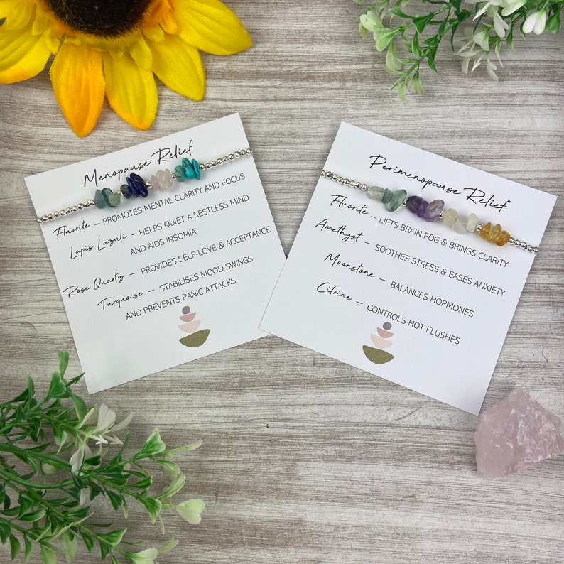 May include: Two white cards with black text describing the benefits of crystals for menopause and perimenopause relief. Each card features a silver bracelet with different colored crystals.