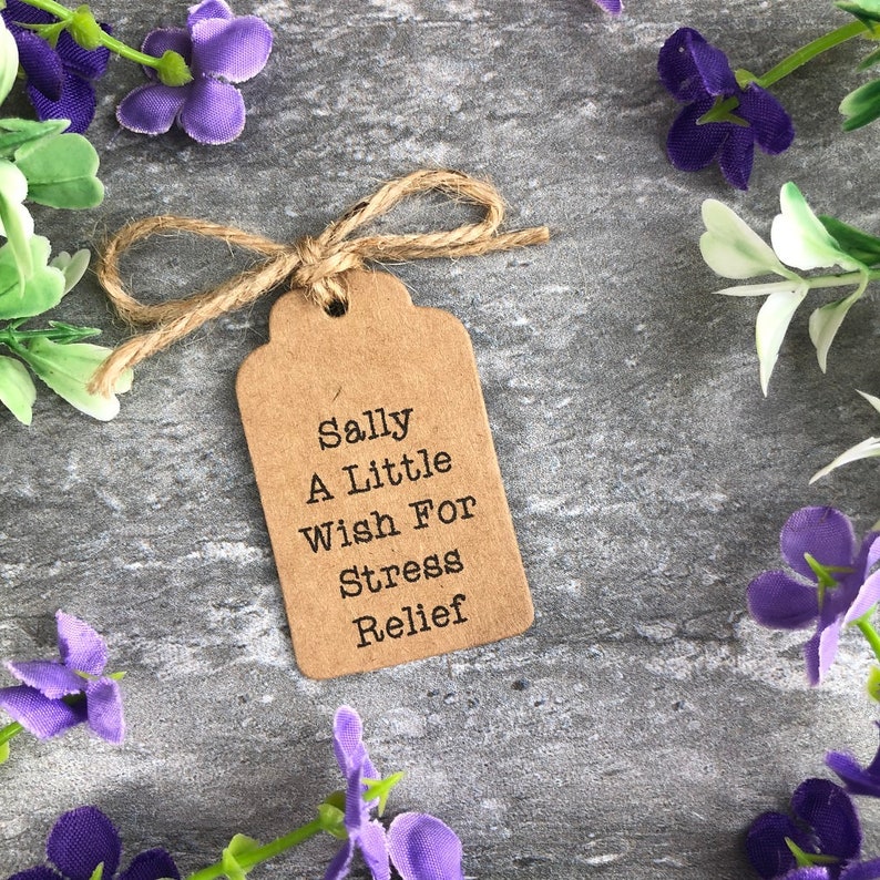 May include: A brown paper gift tag with twine tied around it. The tag has the text "Sally A Little Wish For Stress Relief" printed on it.