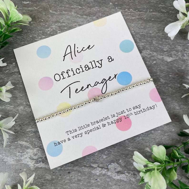 May include: A card with colorful polka dots and the text "Alice Officially a Teenager" with a silver bracelet with a star charm. The card says "This little bracelet is just to say have a very special & happy 13th birthday!"