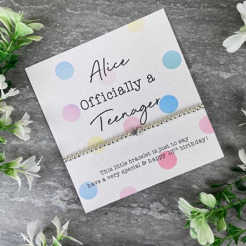 May include: A white card with colorful polka dots and the text "Alice Officially a Teenager" with a silver bracelet with a star charm. The card says "This little bracelet is just to say have a very special & happy 13th birthday!"