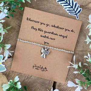 May include: A silver charm bracelet with an angel charm. The bracelet comes with a card that reads "Wherever you go, whatever you do, May this guardian angel watch over you." The card is brown with white text and has the logo "THE persnickety co."
