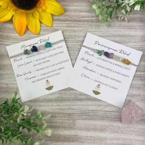 May include: Two white cards with black text describing the benefits of crystals for menopause and perimenopause relief. Each card features a silver bracelet with different colored stones, including fluorite, amethyst, moonstone, rose quartz, lapis lazuli, turquoise, and citrine.