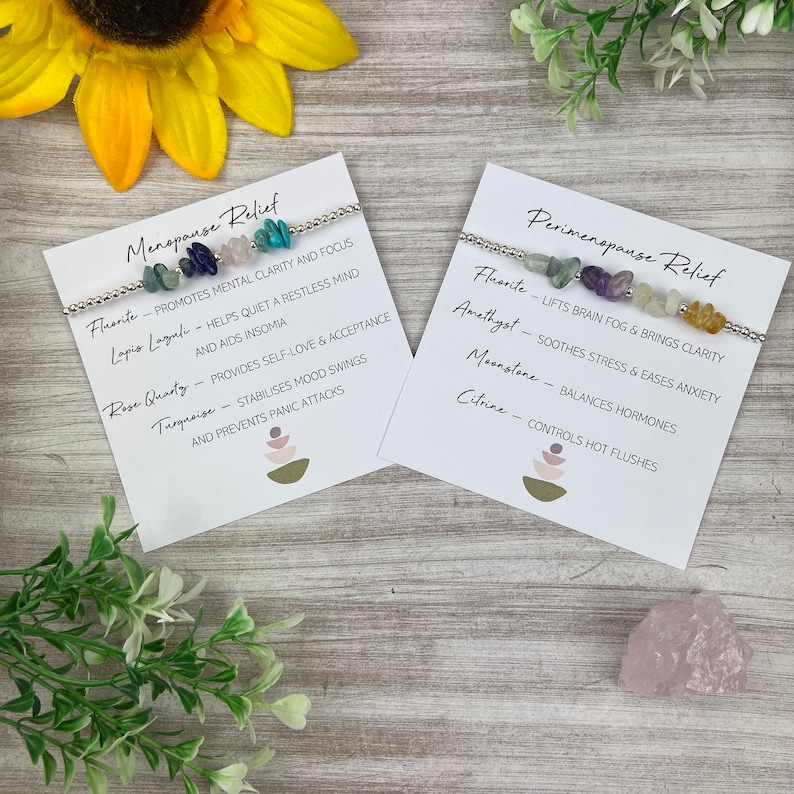May include: Two cards with text about menopause and perimenopause relief. Each card has a silver bracelet with different colored gemstones. The text on the cards lists the gemstones and their associated benefits.