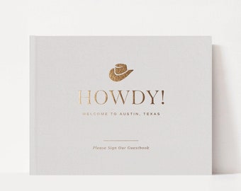May include: A light gray guest book with gold foil text and a cowboy hat icon. The cover reads "HOWDY! WELCOME TO AUSTIN, TEXAS" and "Please Sign Our Guestbook". The book is 10x8 inches.
