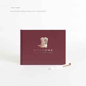 May include: A burgundy guest book with a gold foil design of cowboy boots and the text "WELCOME TO THE WILD WEST LODGE".