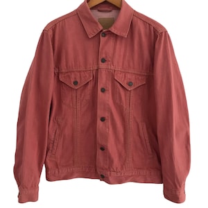 May include: A red denim jacket with a button closure and two front pockets.